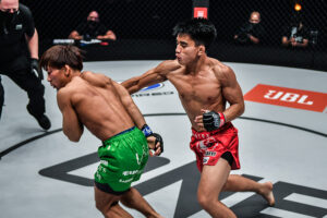 Joshua Pacio lands a right hand on Yosuke Saruta during their strawweight title fight at ONE: 'Revolution' in the Singapore Indoor Stadium