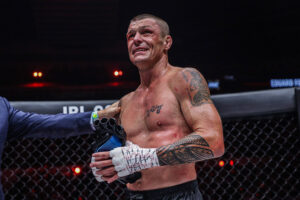 An emotional John Wayne Parr removes his gloves after losing to Eduard Folayang in the final fight of his career at ONE: 'X' in Singapore